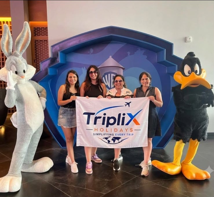 The same four travellers holding the Triplix Holidays flag, with Bugs Bunny and Daffy Duck